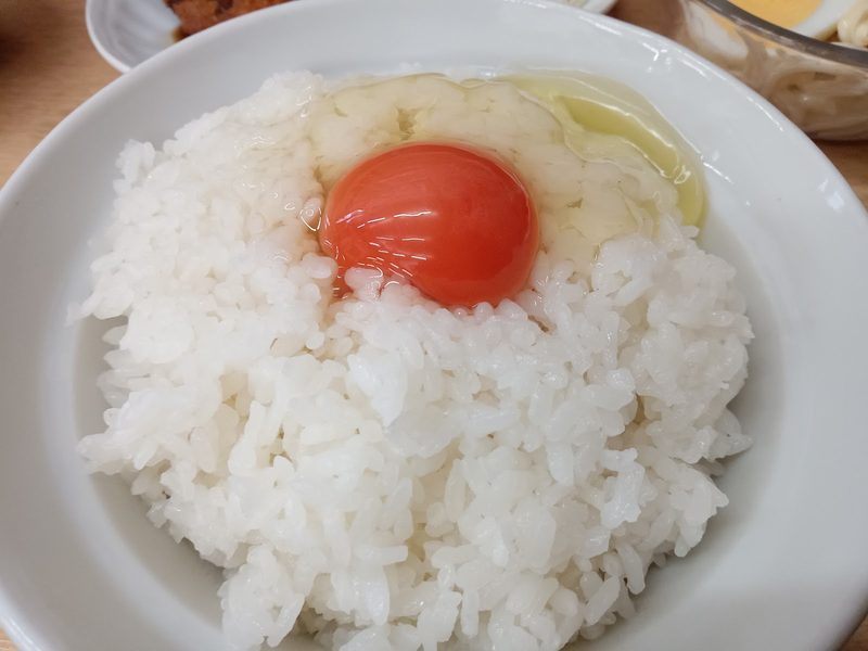 白いご飯の上に、濃いオレンジ色の黄身の生卵をのせた一杯
