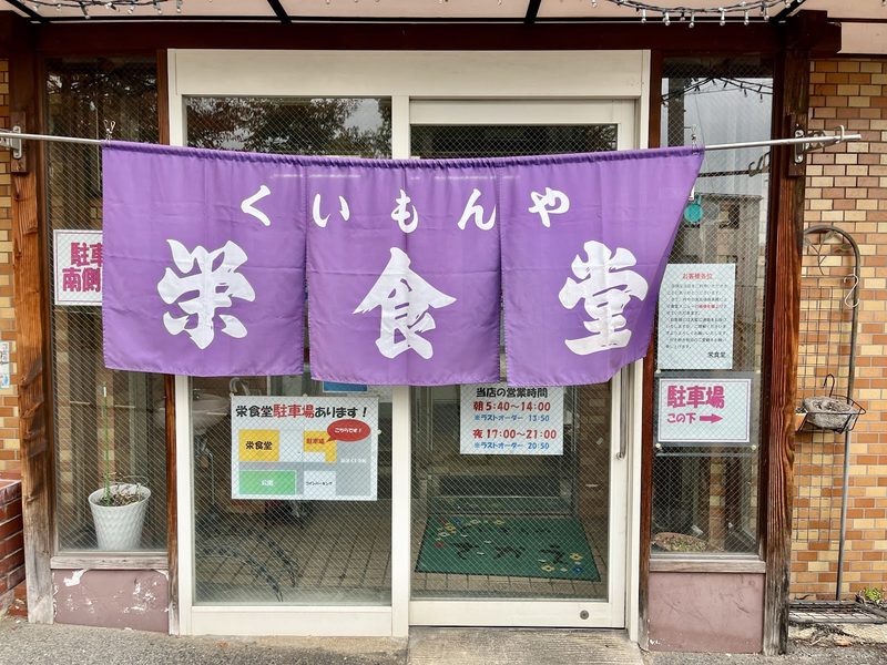 入口に下がる紫の暖簾「くいもんや 栄食堂」
