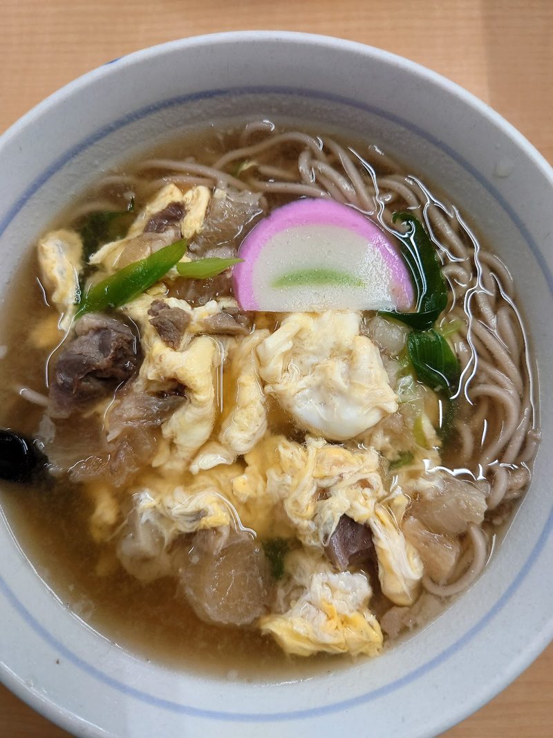 卵とかまぼこ、野菜をのせた温かいそば