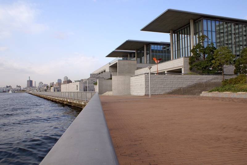 海に面した遊歩道と、庇の張り出したコンクリートの美術館
